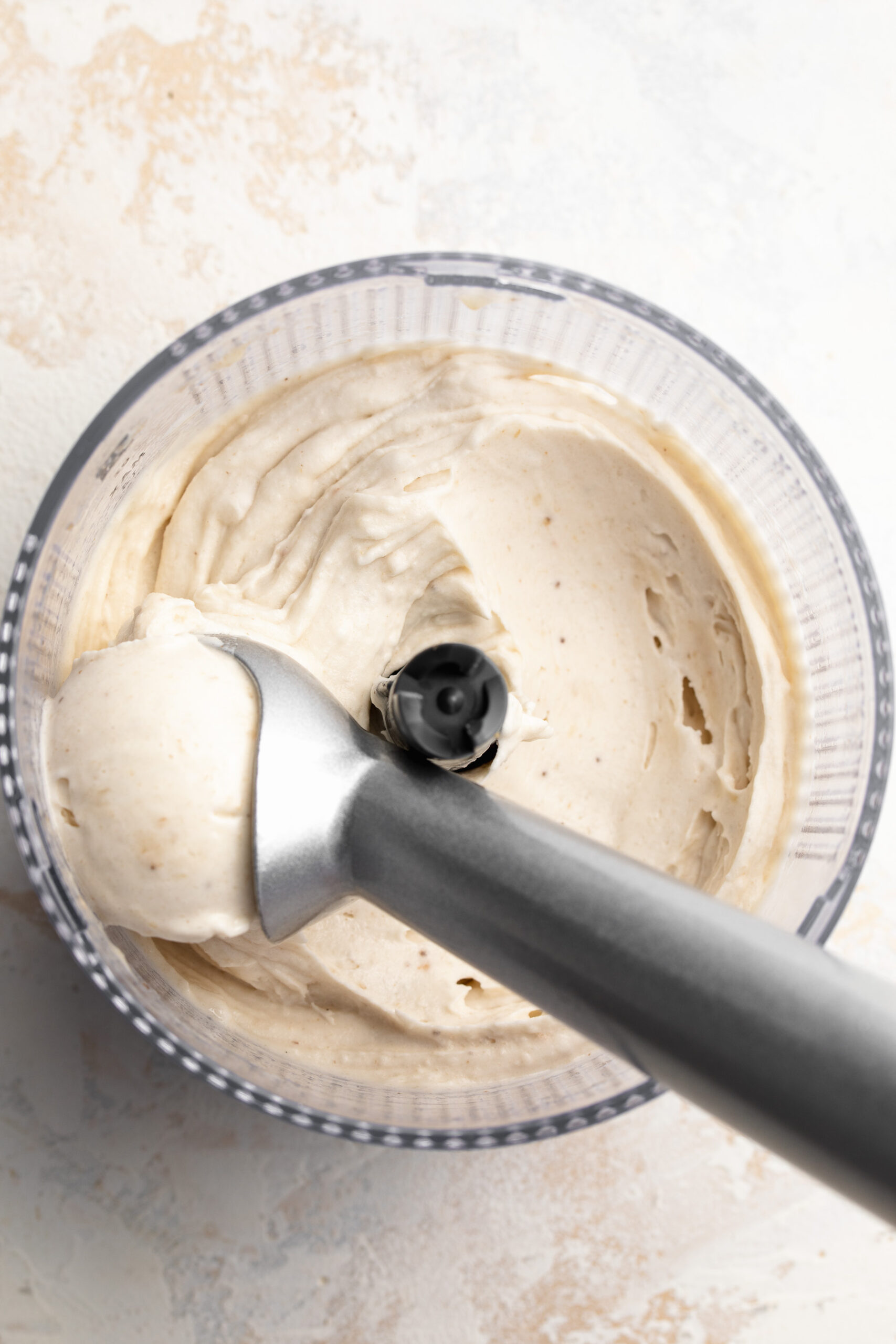 1 ingredient nice cream recipe in a food processor with an ice cream scoop.