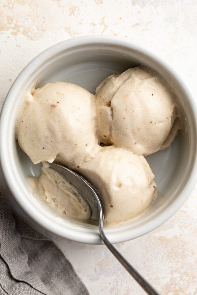 overhead image of nice cream scooped in a bowl with a spoon.