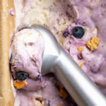 cottage cheese blueberry pie ice cream being scooped with an ice cream scooper.