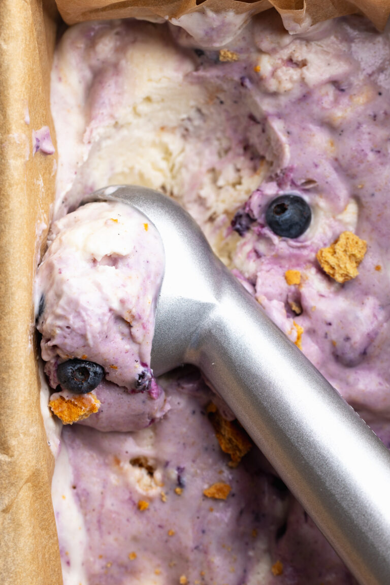 cottage cheese blueberry pie ice cream being scooped with an ice cream scooper.