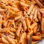 cottage cheese vodka pasta in a skillet with a spoon.