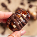 hand holding a butter pecan stuffed date.