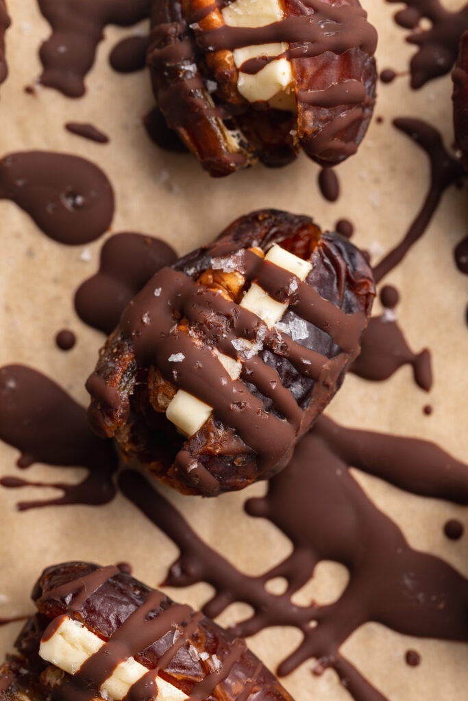 close up image of butter pecan stuffed dates on a plate.