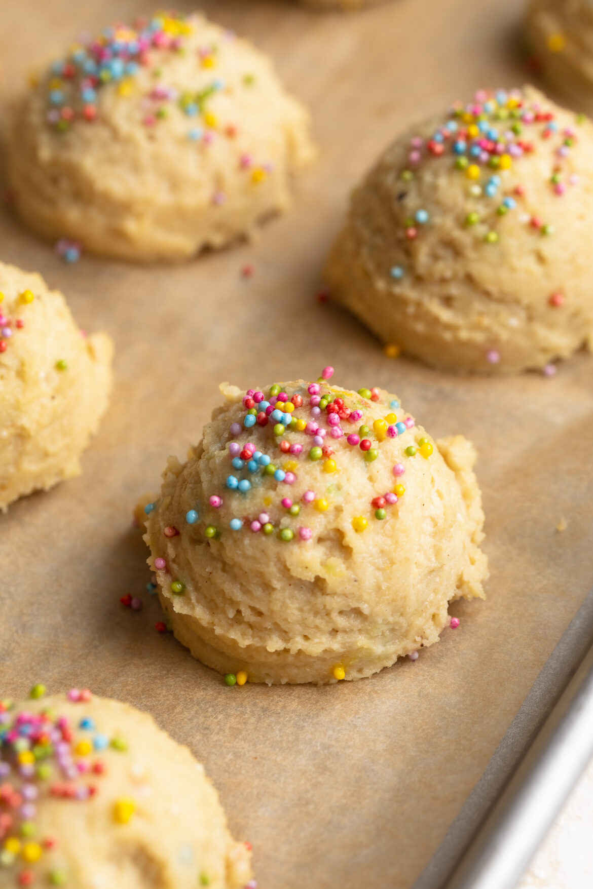 Cottage Cheese Birthday Cake Bites cottage cheese birthday cake bites on a baking sheet with rainbow sprinkles on top.