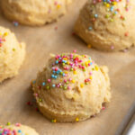 cottage cheese birthday cake bites on a baking sheet with rainbow sprinkles on top.