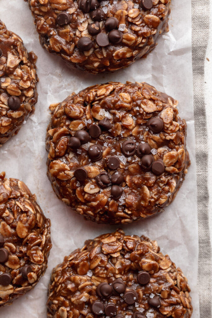 overhead image of no bake cookies on a table with mini chocolate chips and sea salt on top.