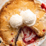 overhead image of 3 ingredient strawberry dump cake in a baking dish with ice cream on top.
