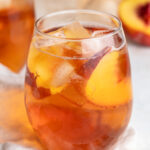 a glass of summer rose sangria with fresh sliced peaches inside.