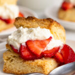 close up image of a strawberry shortcake stuffed with whipped cream and strawberries.