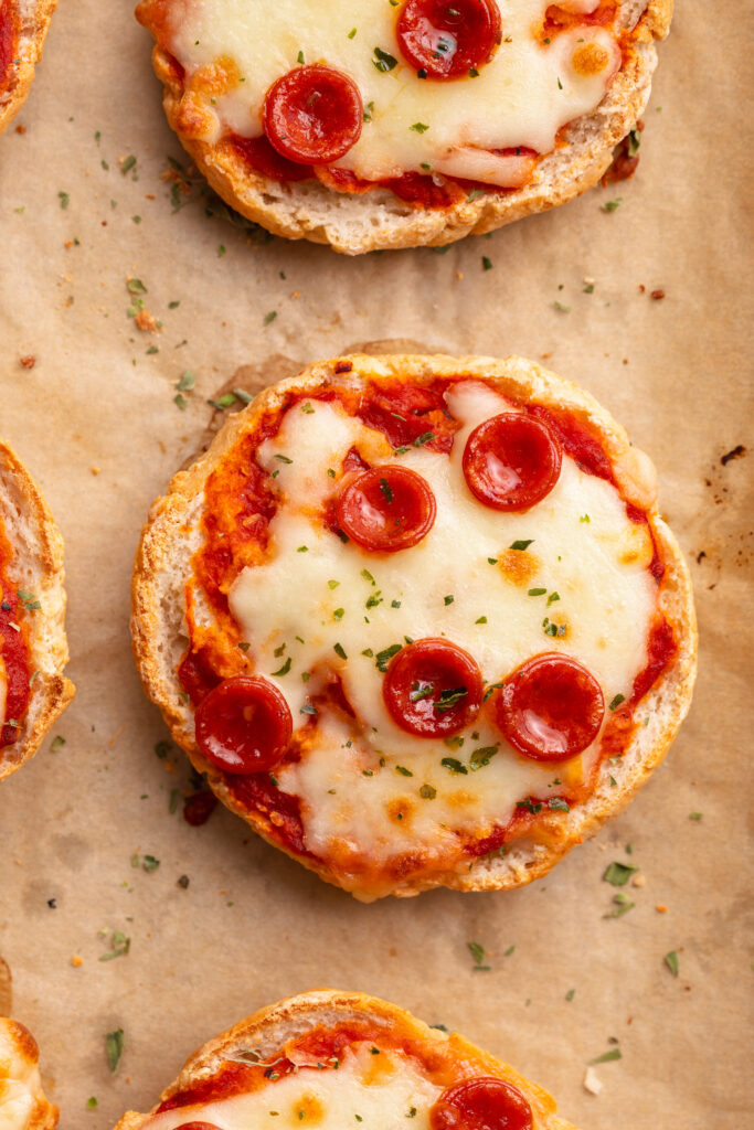 overhead image of cottage cheese pizza bagels on a baking sheet.