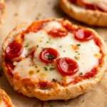 close up image of cottage cheese pizza bagels on a baking sheet.