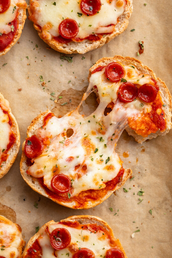 pulling apart a cottage cheese pizza bagel.