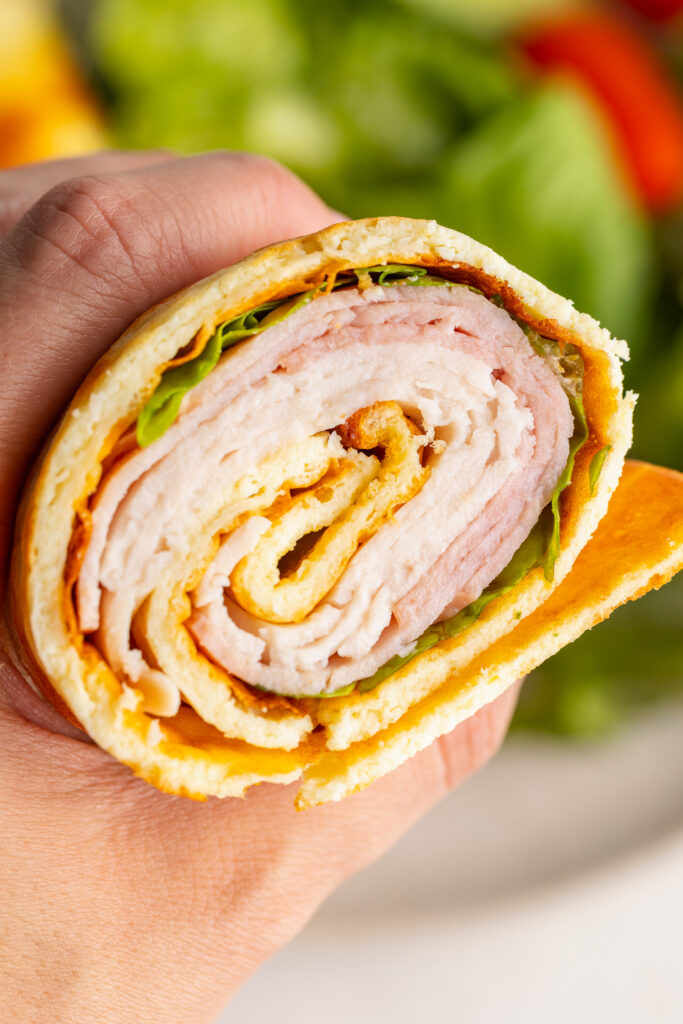 close up image holding half a cottage cheese wrap.