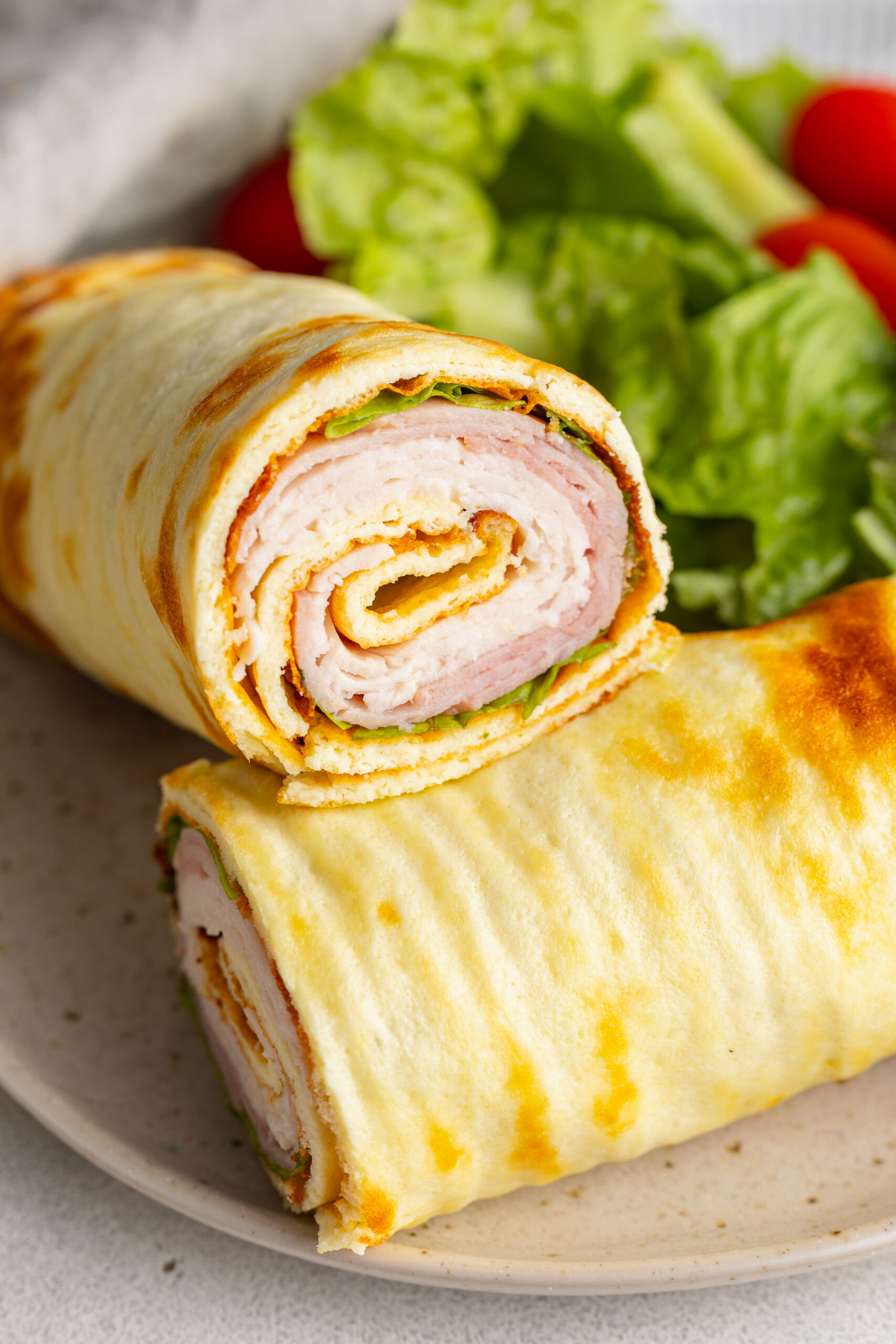 cottage cheese wrap halves stacked on a plate.