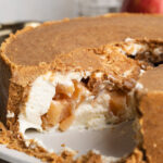upside down cheesecake being cut into with apple pie filling inside.