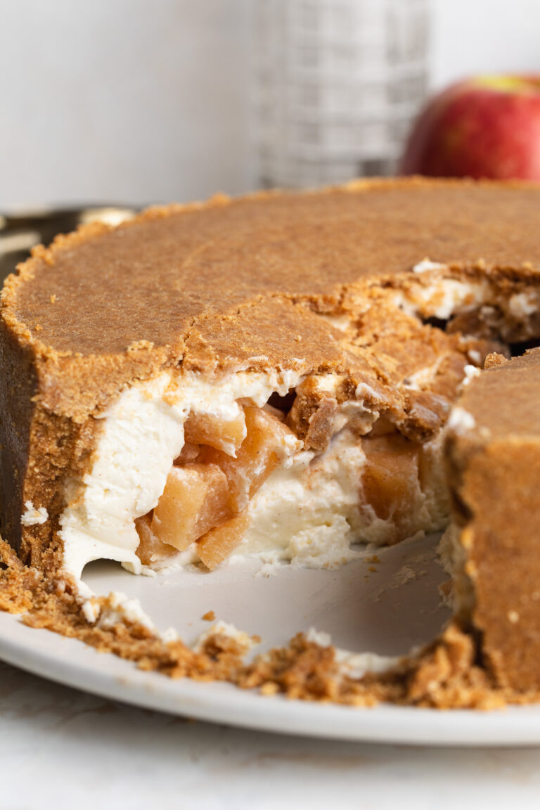 upside down cheesecake being cut into with apple pie filling inside.