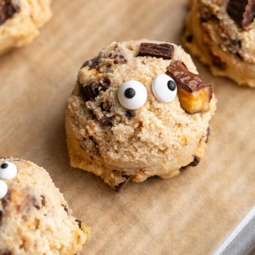 close up image of a cottage cheese monster cookie dough bite on a baking sheet.