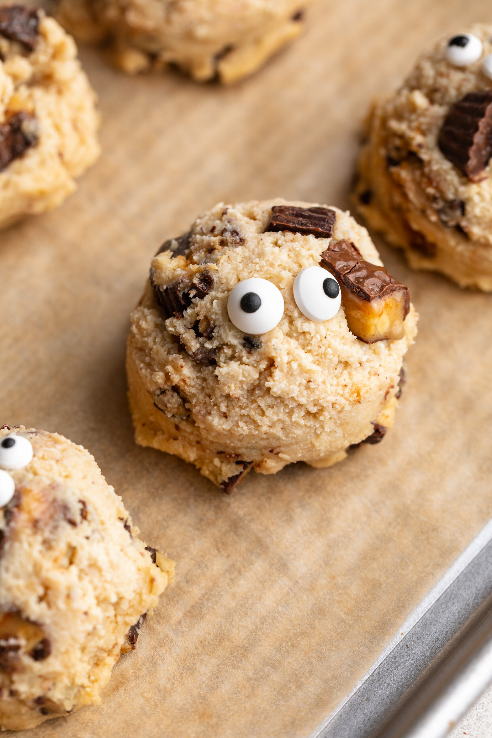 close up image of a cottage cheese monster cookie dough bite on a baking sheet.