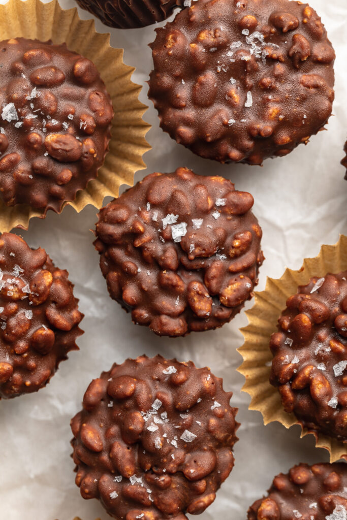 overhead image of crunchy peanut butter cups on a table with sea salt on top.