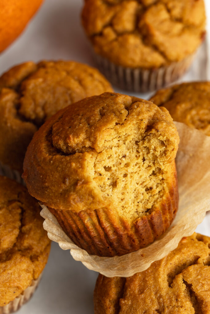 close up image of a pumpkin protein muffin with a bite taken out.